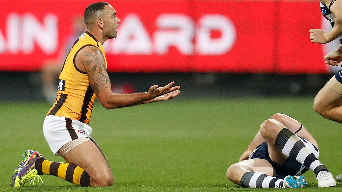 Patrick Dangerfield of the Cats lays injured after being tackled by Shaun Burgoyne of the Hawks
