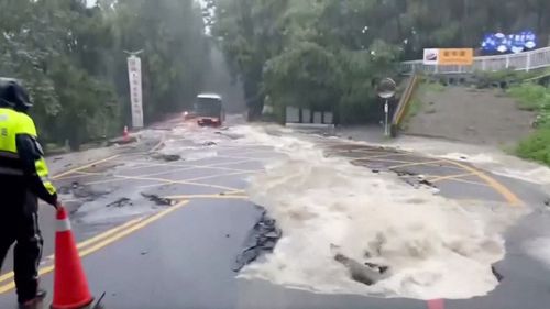 A person stands on a flooded street following heavy rains due to Typhoon Khanun, in Nantou county, Taiwan August 5, 2023. 