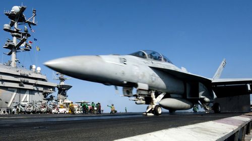 A fighter jet sits on a US aircraft carrier