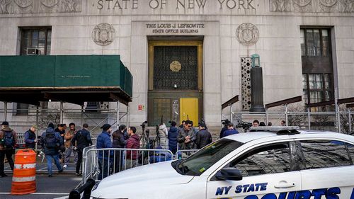 Journalists gather outside the public entrance of a New York building where a grand jury gathered to consider charges against Donald Trump.