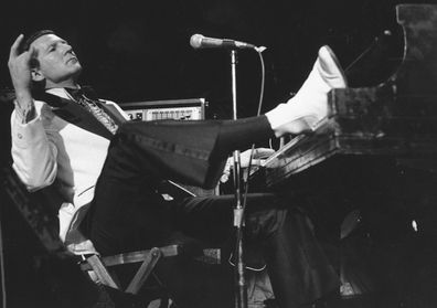 Jerry Lee Lewis props his foot on the piano as he lays back and acknowledges the applause of fans during the fifth annual Rock 'n' Roll Revival at New York's Madison Square Garden on March 14, 1975.  