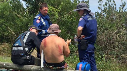 Paramedics with an injured man at Crescent Head. (Supplied)