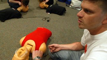 An Australian Red Cross worker demonstrates how to give CPR