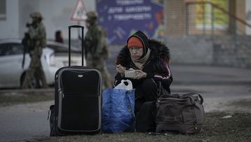 A refugee woman eats in Brovary, Ukraine, Sunday, March 20, 2022, after 1,600 people, of which half are children according to authorities, were evacuated from the village of Bobrik, reportedly under Russian military control. Russian forces pushed deeper into Ukraine&#x27;s besieged and battered port city of Mariupol.