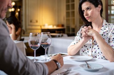 Adult couple arguing at a restaurant during a dinner.