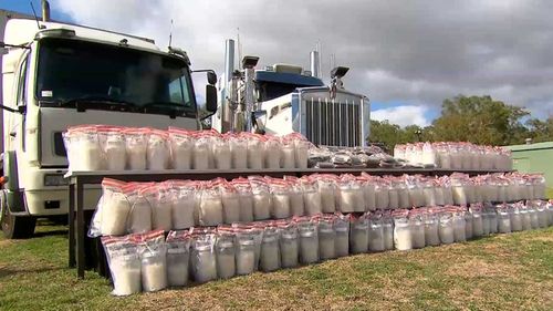 Armed police were on guard at the press event to show off the captured meth and cash.