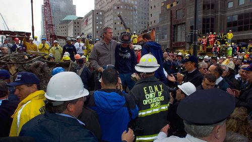 President George W Bush speaks to a group of firefighters amidst the rubble of the World Trade Centre.
