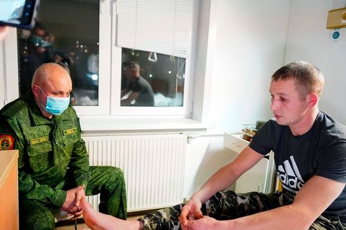 Kemerovo Governor Sergei Tsivilyov, left, visits a wounded miner after the accident at the Listvyazhnaya coal mine