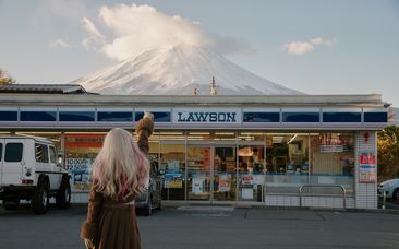 Yamanashi, Japan - Nov 18, 2023: Picture of the Lawson convenience store in Kawaguchiko City, back of Asian woman and views of Mount Fuji.