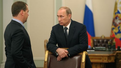 Russian President Vladimir Putin speaks to Prime Minister Dmitry Medvedev after a moment of silence mourning the victims killed in the Malaysia Airlines plane crash on Thursday, July 17. (AP Photo)