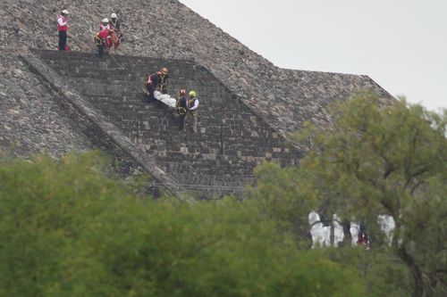 Forensic workers carry the body of a victim down a pyramid after authorities said a gunman opened fire, in Teotihuacan, Mexico, Monday, April 20, 2026.