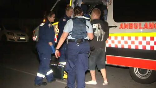 A man is escorted by police to an ambulance following the alleged attack. (9NEWS)