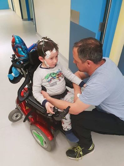 William in his power wheelchair, with is dad Ben.