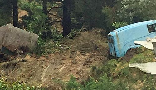 Vehicles were pushed down the slope after the landslide in Dunedin on Saturday. (Photo: Keith Kelsall).