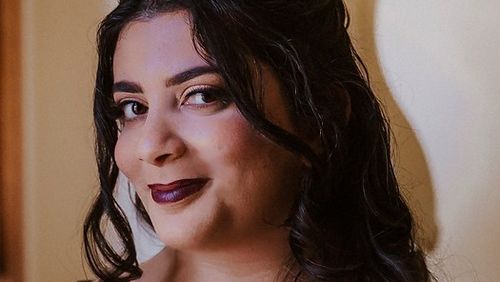 La dottoressa Susannah French sorride alla telecamera. I suoi capelli sono arricciati e indossa una corona.