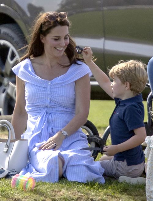 Prince George plays with a toy knife as he sits with his mother. Picture: AAP