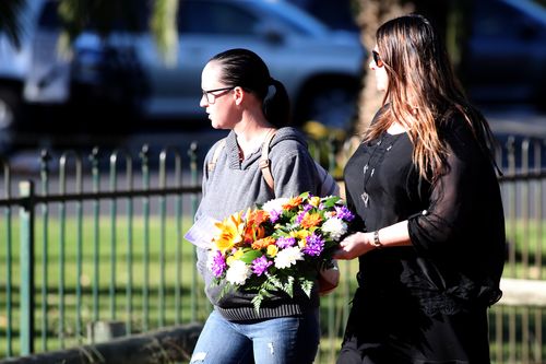 Mourners brought floral tributes to remember the family. (AAP)