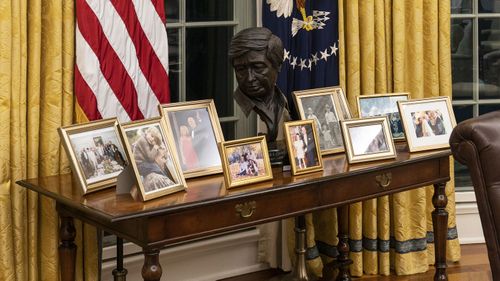 The Oval Office of the White House is newly redecorated for the first day of President Joe Biden's administration, Wednesday, Jan. 20, 2021, in Washington, including a table with family photos.