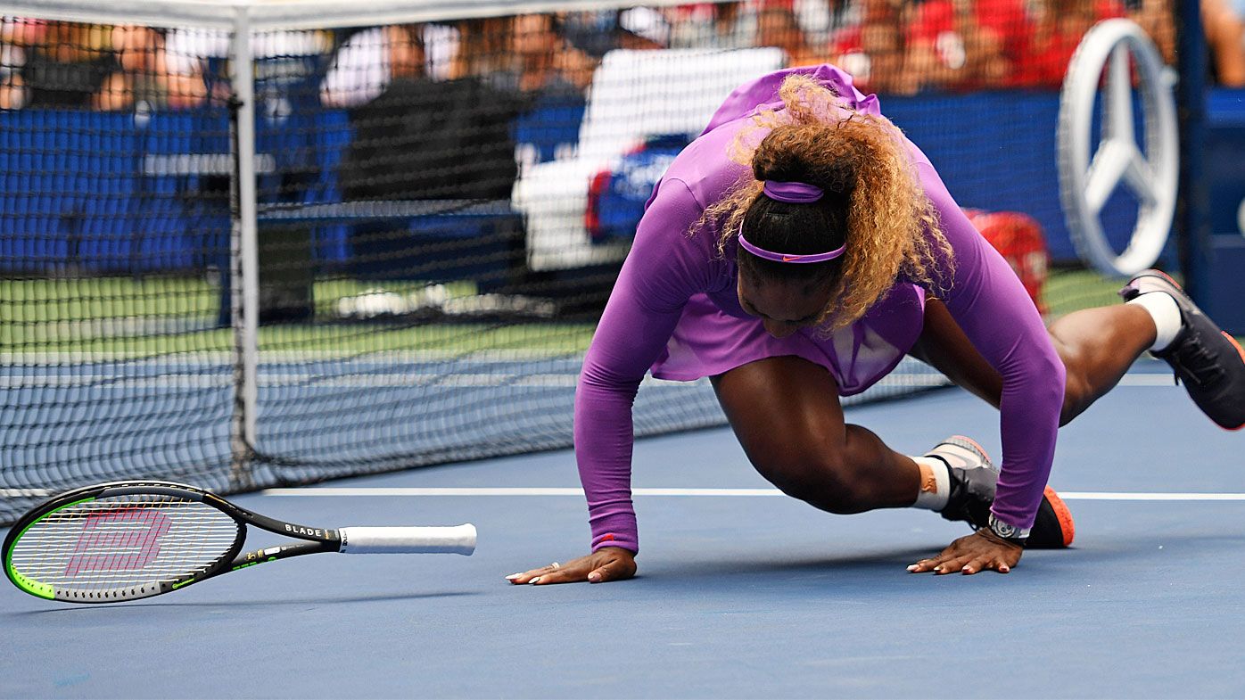 Serena Williams, of the United States, falls while chasing a return to Petra Martic