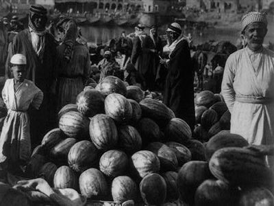 In this photo taken in 1932, men hang out in the fruit
market with a pile of watermelons ready for buyers.<br />
(American Colony Photo Department)