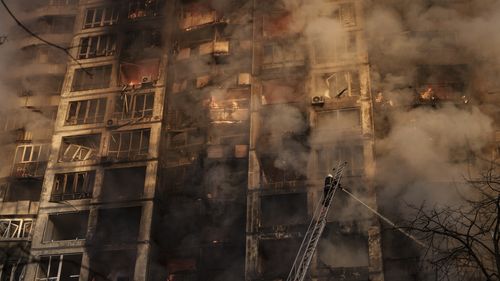 Ukraińscy strażacy pracują w bloku po bombardowaniu Kijowa na Ukrainie.