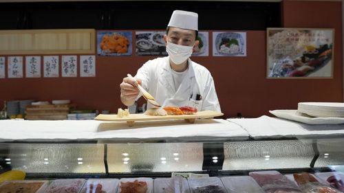 FILE - A sushi chef prepares a plate at the Toyosu Market Monday, Jan. 29, 2024, in Tokyo. Japan has slipped to the worlds fourth-largest economy as government data released Thursday, Feb. 14, 2024, showed it fell behind the size of Germany's in 2023. (AP Photo/Eugene Hoshiko, File)