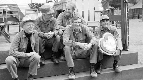 FILE - Cast members of the television series "M*A*S*H," from left, William Christopher, Harry Morgan, Mike Farrell, Alan Alda, and Jamie Farr, appear on the set during taping in Los Angeles on Sept. 15, 1982. (AP Photo/Wally Fong, File)