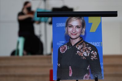 A musician plays a violin behind a photograph of cinematographer Halyna Hutchins during a vigil in her honor in Albuquerque, N.M., Saturday, Oct. 23, 2021. 