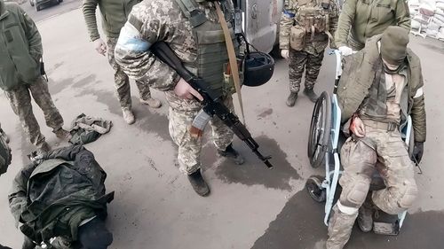 Two injured Russian soldiers, left and right, arrive at a hospital to be treated on March 10, 2022, in Mariupol, Ukraine. "They will not be as kind to us as we'll be to them," Yuliia Paievska, known as Taira, says about treating the soldiers. "But I couldn't do otherwise. They are prisoners of war."
