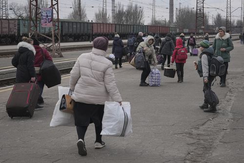 People waiting for a Kyiv bound train spread on a platform in Kostiantynivka, the Donetsk region, eastern Ukraine, Thursday, Feb. 24, 2022. 