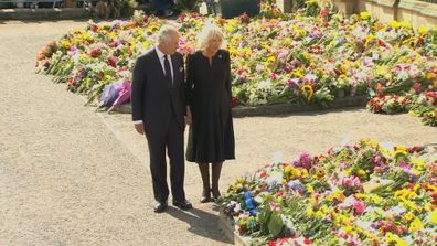 The King and Queen look at tributes of flowers in Belfast.
