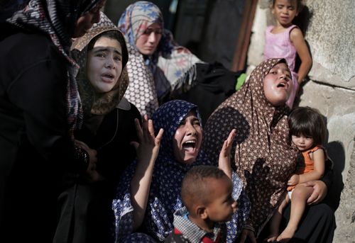 Palestinian relatives of four boys from the same extended Bakr family, grieve during their funeral in Gaza City, Wednesday, July 16, 2014. (AAP)