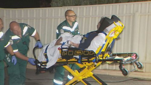 Ms Cox being taken to hospital for treatment after allegedly being attacked by a police dog.