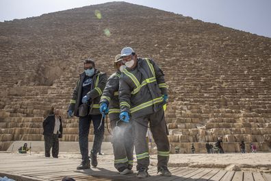 Municipal workers sanitize the Giza Pyramids as prevention measures due to the coronavirus outbreak, in Egypt, Wednesday, March 25, 2020.