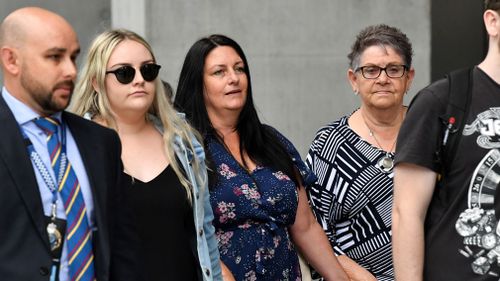 The wife (centre) and family members of victim Shane Merrigan are seen leaving the Supreme Court in Brisbane. (Image: AAP)