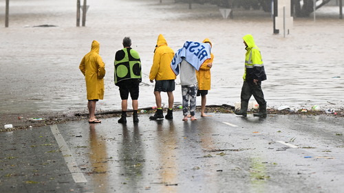 Local residents inspect a flooded road on March 30, 2022 in Lismore, Australia. 