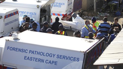 FILE - A body is removed from a nightclub where 21 teenagers died in the early hours of the morning, in East London, South Africa, Sunday June 26, 2022. The toxic chemical methanol has been identified as a possible cause of the deaths of 21 teenagers at a bar in the South African city of East London last month, authorities said at press conference in East London Tuesday. July 19, 2022.  (AP Photo/File)