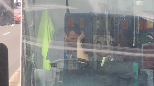 A bus driver sits at the wheel with his head in his hand after almost two hours in bumper-to-bumper traffic. (Supplied, Cherry Chen)