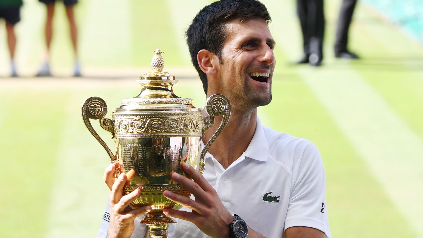 Novak Djokovic celebrates with the Wimbledon trophy.