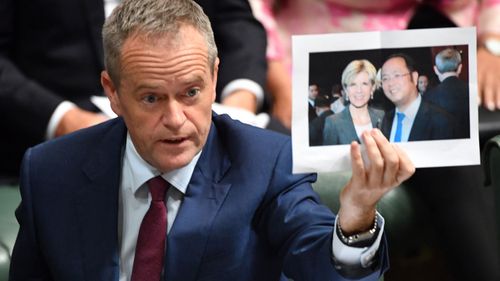 Leader of the Opposition Bill Shorten holds a photograph of Minister for Foreign Affairs Julie Bishop and chinese businessman Huang Xiangmo during Question Time in July. (AAP)