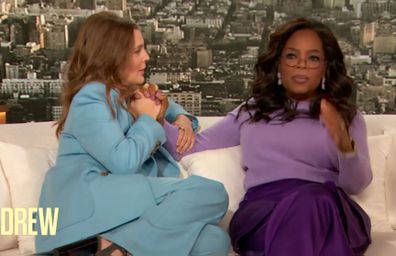 Drew Barrymore holding and caressing Oprah Winfrey's hand during interview on The Drew Barrymore Show