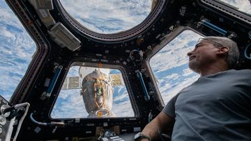 NASA astronaut Mark Vande Hei is seen aboard the International Space Station in this Feb. 9, 2022 photo. A Russian Soyuz spacecraft is docked outside. 