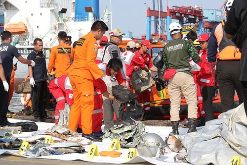 Indonesian rescue team members collecting the remains of the crashed plane at Tanjung Priok Harbour.