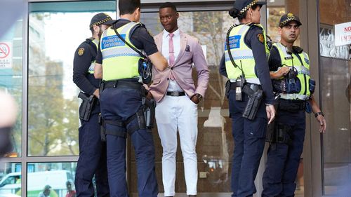 Protective Service Officers speak to Yoa after he was knocked back from an express court entrance.