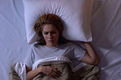 Upset female awakening in bed, disappointed with bad dream, suffering nightmares