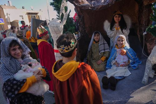 Vestidas com trajes tradicionais, as crianças participam do 40º desfile anual de Natal em direção à Basílica da Anunciação em Nazaré, Israel.