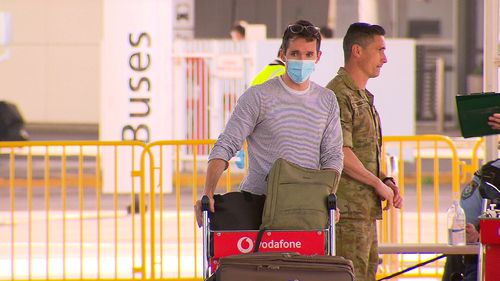 Bill Birtles, a reporter with the ABC, pushes his luggage through the airport in Sydney.