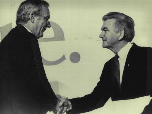 Bill Hayden holds Bob Hawke's hand after Mr. Hawke Praised Mr. Hayden in his speech today in Hobart. July 9, 1986.