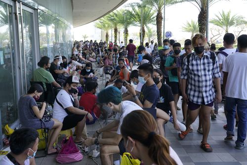 Residents line up to charge their phones for free at a mall after Typhoon Rai damaged power lines and other parts of Cebu city, central Philippines on Saturday, Dec. 18, 2021. 