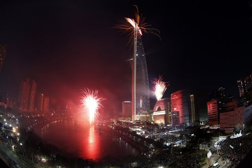 Fireworks explode over the world's fifth 123-storey Lotte World Tower during New Year celebrations in Seoul, South Korea. (AAP)